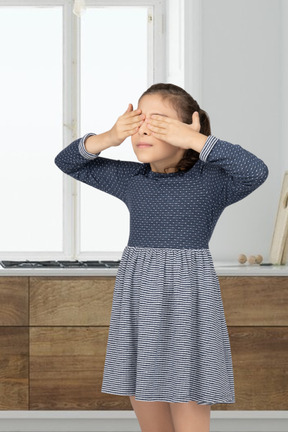 Ragazza in piedi e coprendosi gli occhi