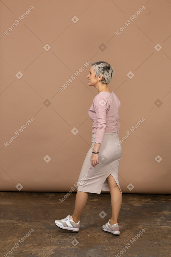 カジュアルな服を着て歩く女性の側面図