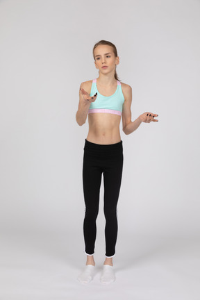 Side view of a teen girl in sportswear raising hand and arguing