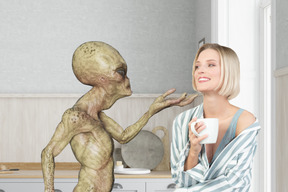 A woman holding a cup of coffee in front of an alien