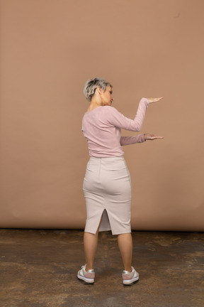 Retrovisor de uma mulher com roupas casuais mostrando o tamanho de algo