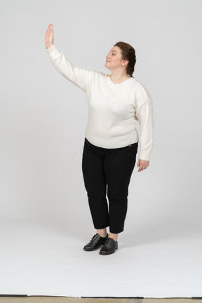 Vista frontal de una mujer de talla grande en ropa casual saludando a alguien