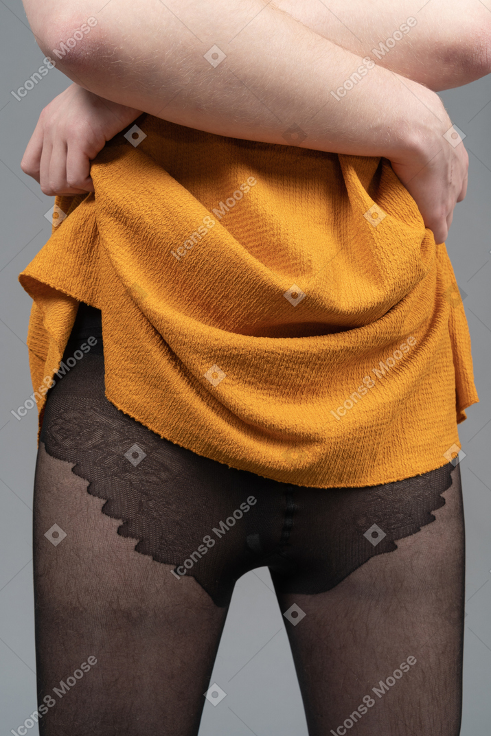 Foto ritagliata di una persona che si toglie il vestito arancione