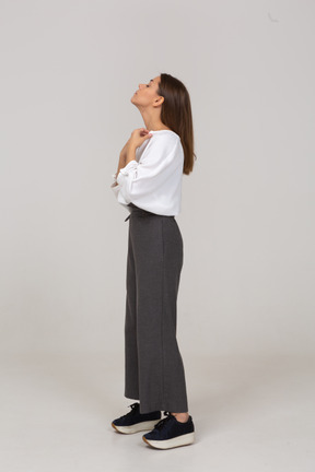 Side view of a young lady in office clothing adjusting her blouse