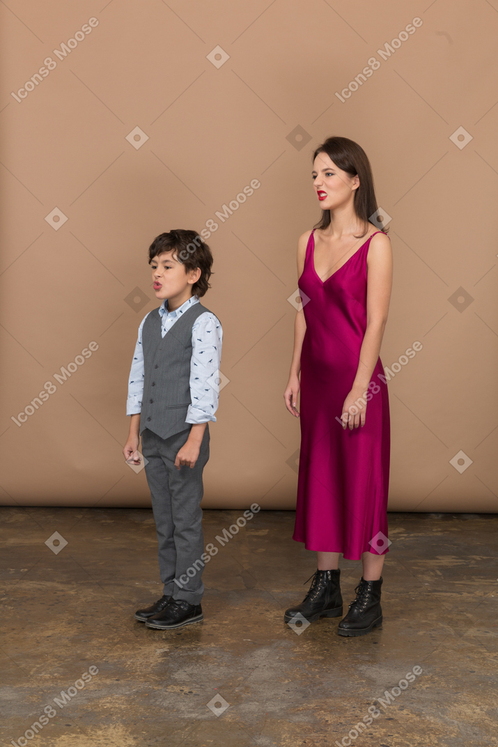 Vista frontal de um menino e uma mulher sorrindo com um vestido vermelho