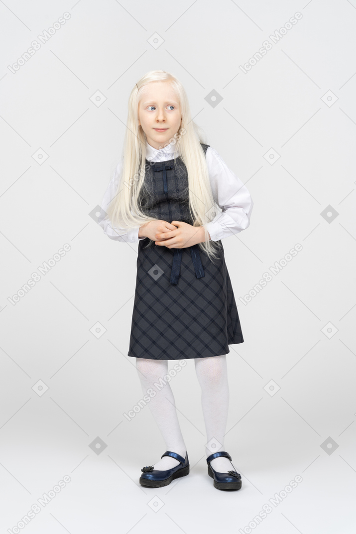 Schoolgirl looking curious with hands over stomach