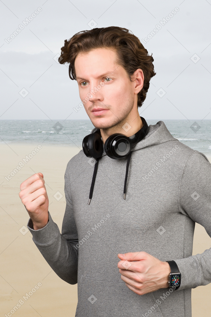 Correndo ao longo da beira-mar com fones de ouvido