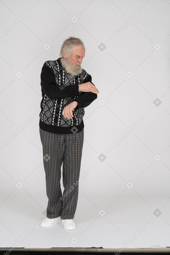 Старший мужчина удаляет грязь со своего свитера