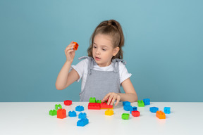 Little girl holding a red lego block