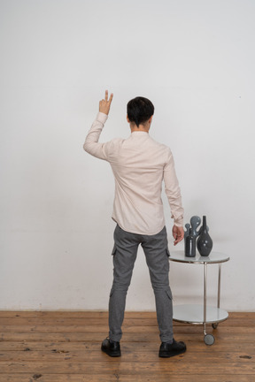 Vista posteriore di un uomo in camicia che mostra il segno v