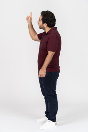 Side view of a man in casual clothes pointing