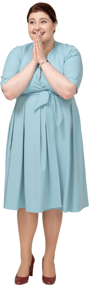 Vista frontale di una donna felice in abito blu che gesticola