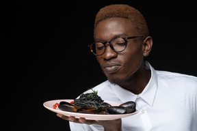 Close-up chef smelling seafood pasta