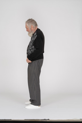 Side view of an old man in casual clothes looking down