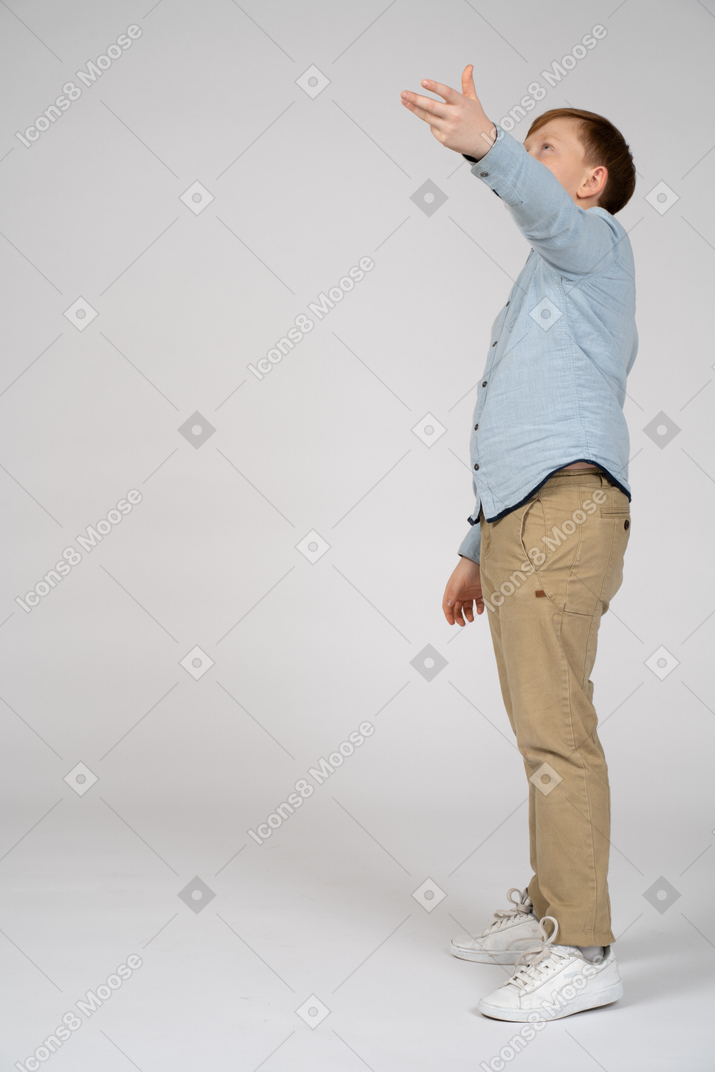 Vue latérale d'un garçon pointant vers le haut avec la main