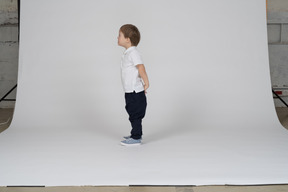 Side view of a little boy standing upright