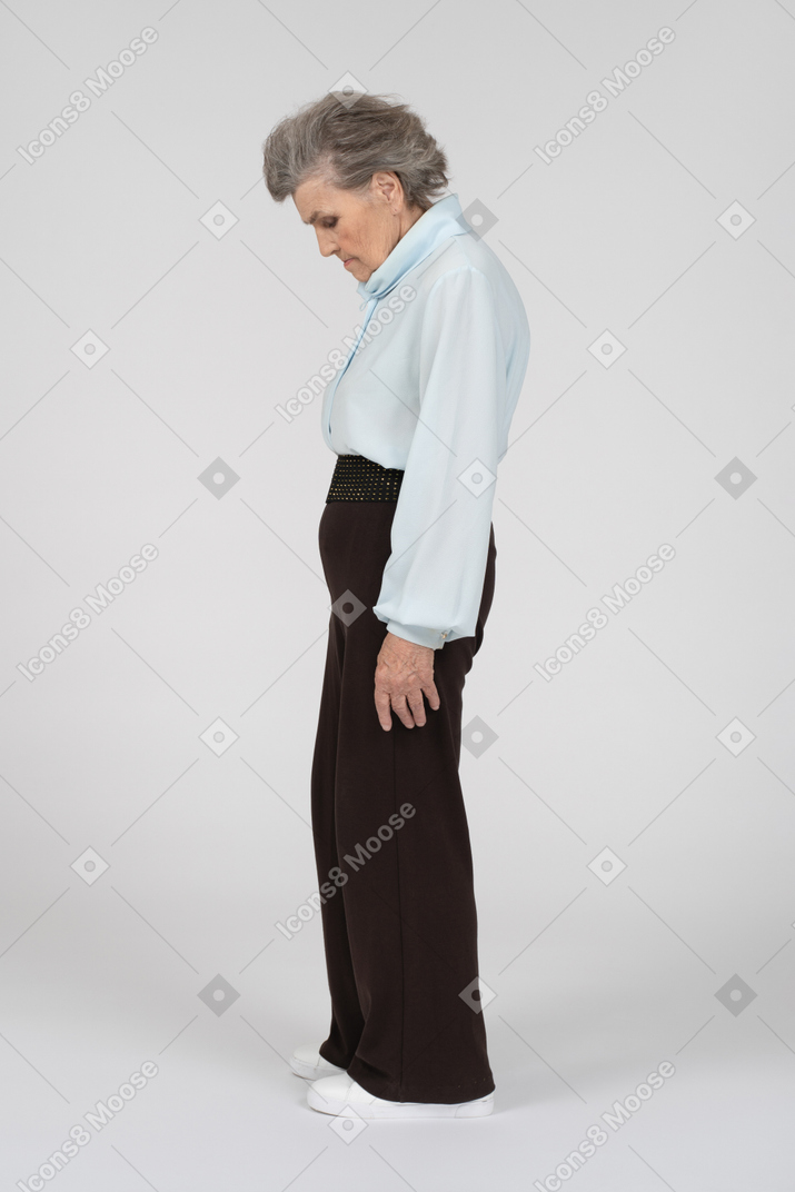 Side view of old lady standing with head down