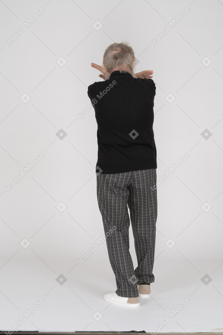 Rear view of old man crossing hands