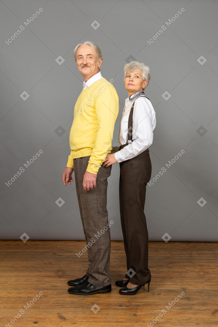 Uomo sorridente in piedi con sua moglie dietro di lui
