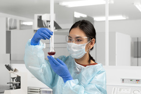 A woman in a lab coat holding a test tube