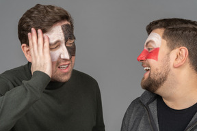 Front view of two male football fans sharing their emotions