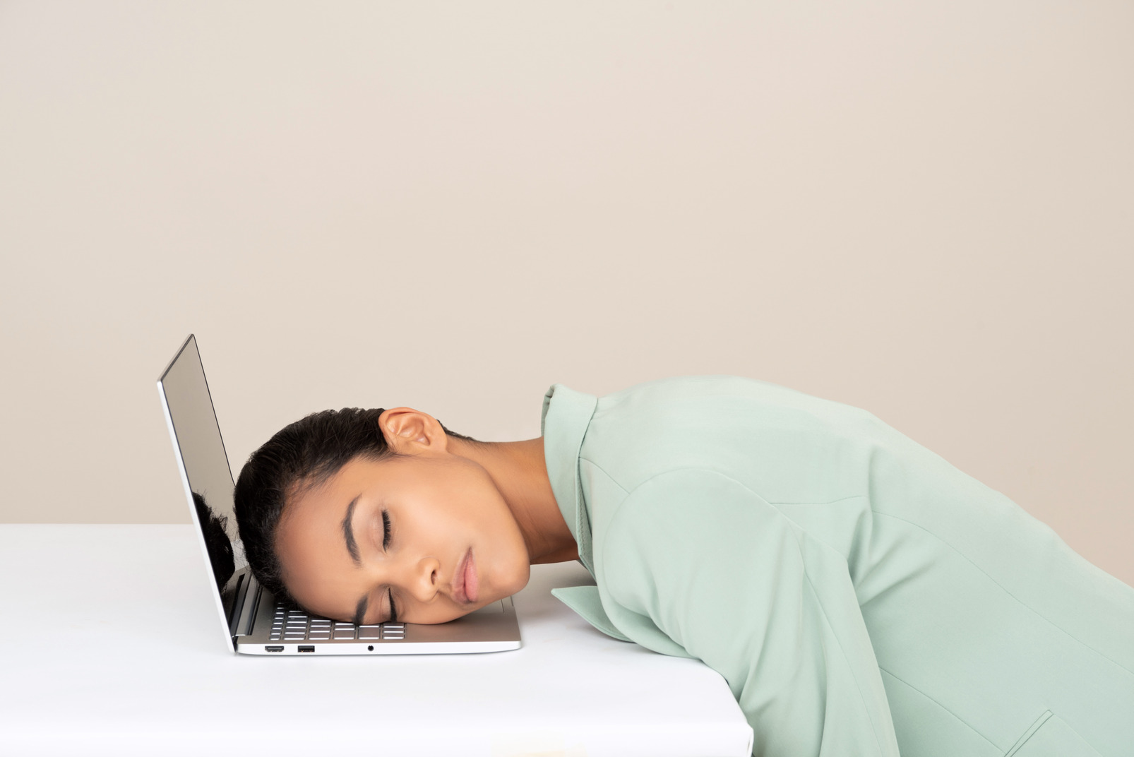 Young businesswoman sleeping at her workplace