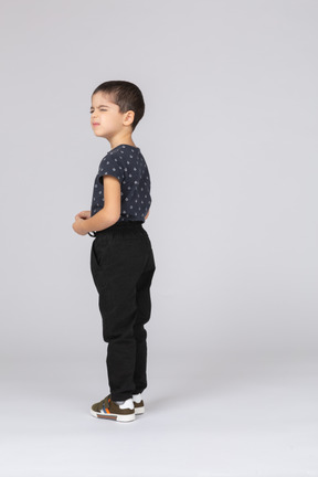 Вид сбоку на симпатичного мальчика в повседневной одежде, смотрящего вверх