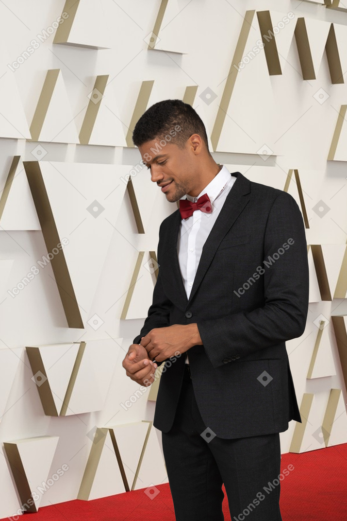 A man in a suit standing on a red carpet