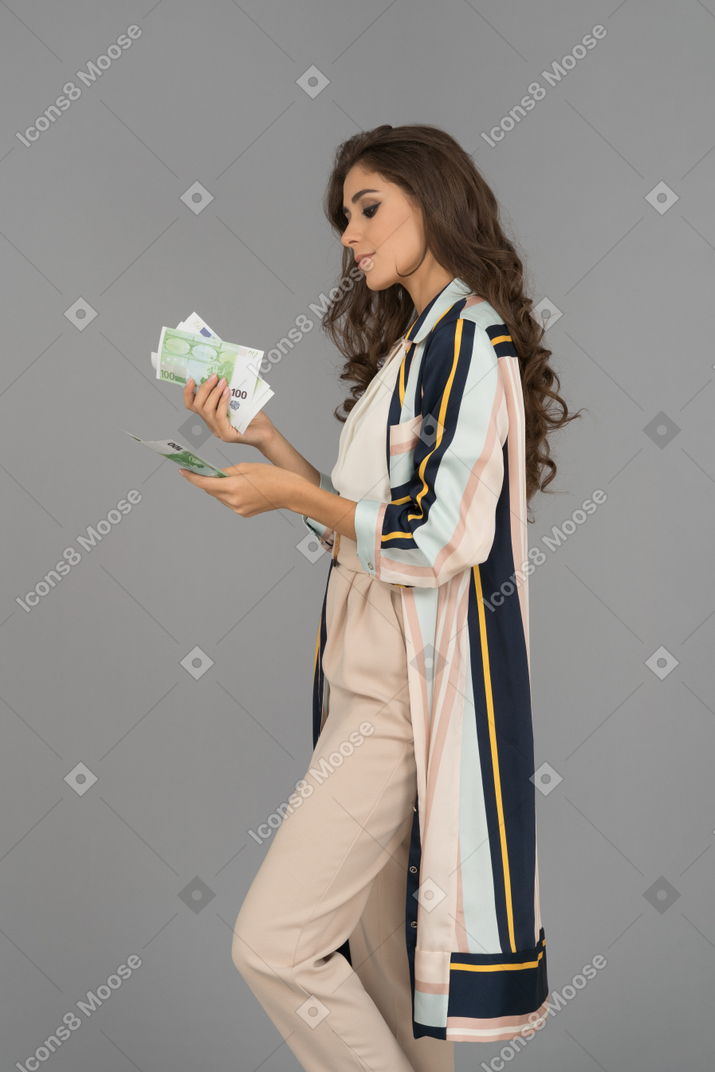 Красивая арабская женщина считает деньги в профиле
