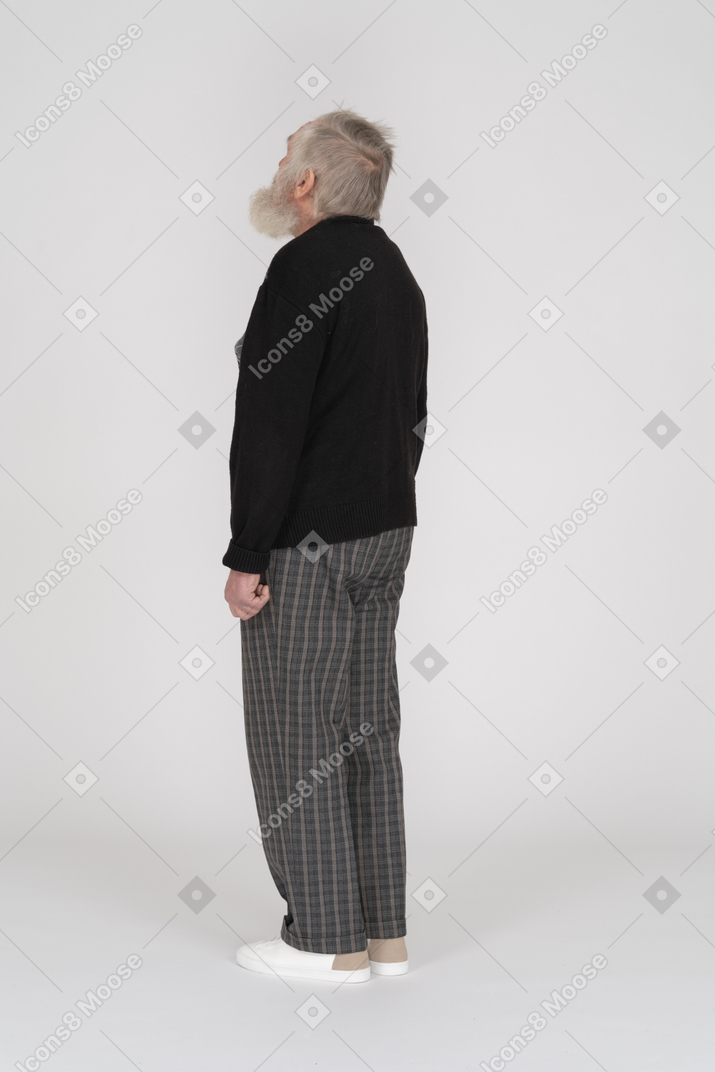 Three quarter back view of an old man standing with head up