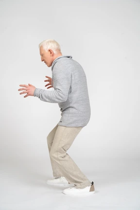 Side view of a man with knees bent and hands spread