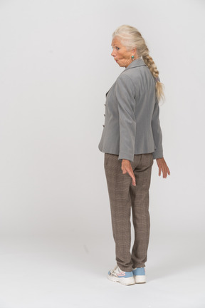 Rear view of an old lady in suit making faces
