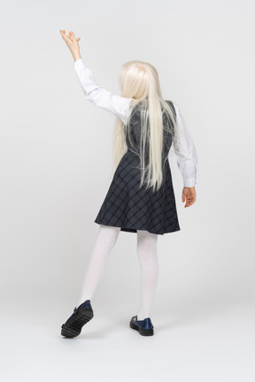 Back view of a schoolgirl reaching up