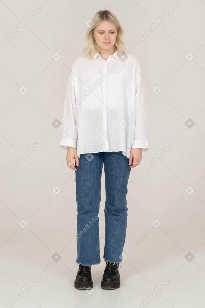 Front view of a cute blonde female in casual clothes looking down