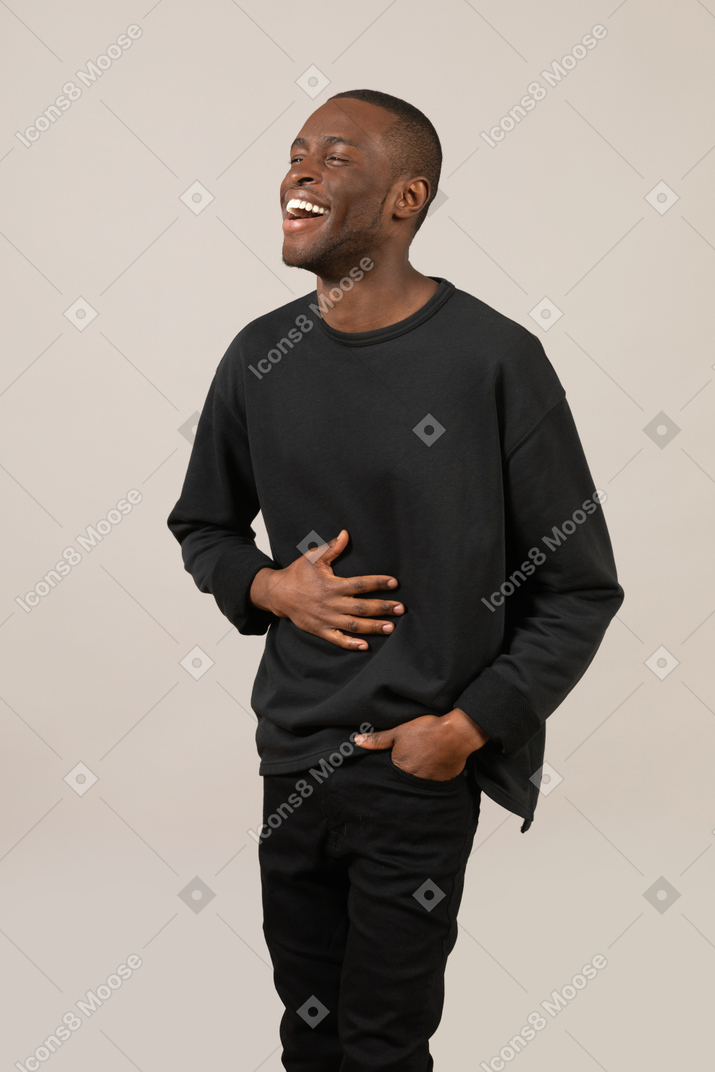 Jeune homme riant et tenant son estomac