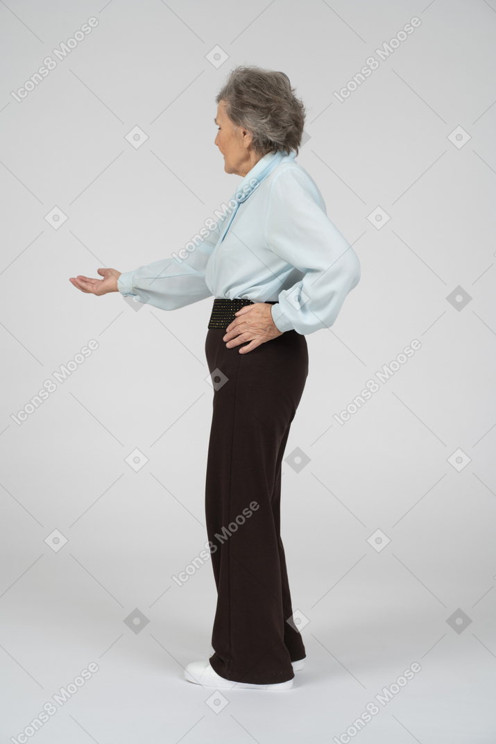 Side view of an old woman stretching out her hand