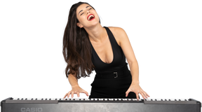 Front view of a pleased young lady in black dress playing the piano while singing