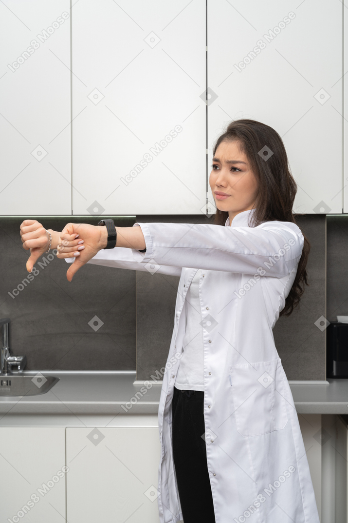 Close-up de uma médica mostrando gesto de antipatia com as duas mãos
