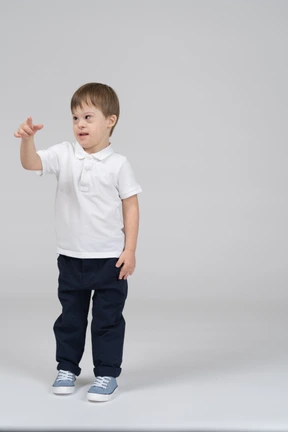 Front view of little boy pointing his finger at camera