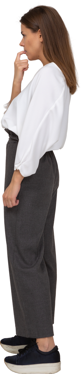Side view of a young lady in office clothing biting her finger