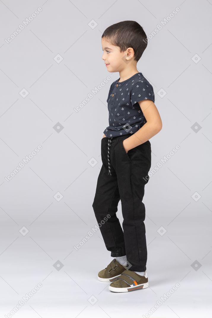 Side view of a cute boy posing with hands in pockets