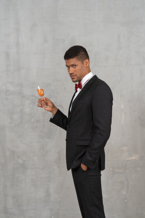 Man holding a flute glass and looking at camera