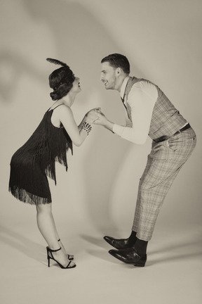 Hombre y mujer tomados de la mano mientras baila charleston