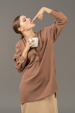 Lady with coffee cup licking her fingertip