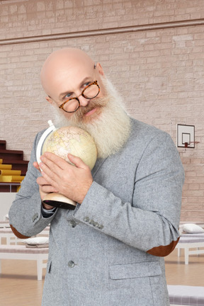 A man with a bald head holding a globe