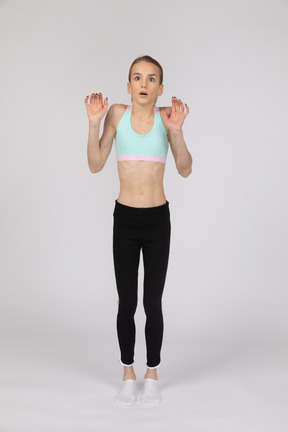 Side view of a teen girl in sportswear raising hand and arguing