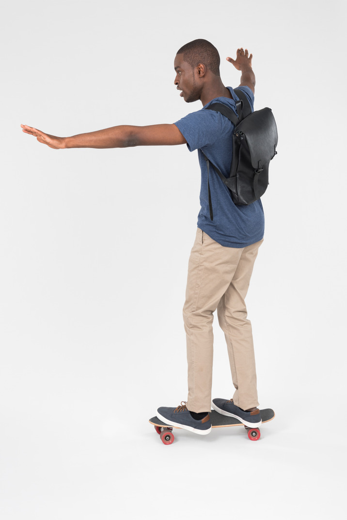 Black male tourist standing on skateboard