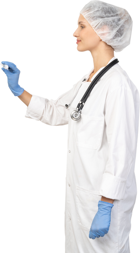 Vue latérale d'une jeune femme médecin avec stéthoscope tenant un thermomètre