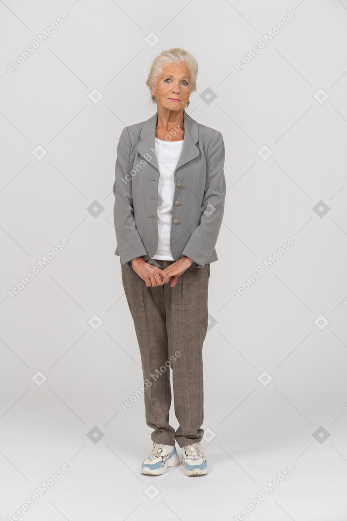 Vorderansicht einer alten dame im anzug mit blick in die kamera