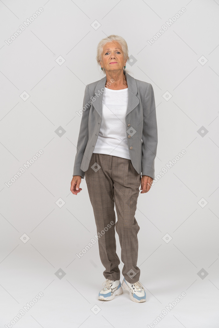 Vue de face d'une vieille dame en costume regardant la caméra